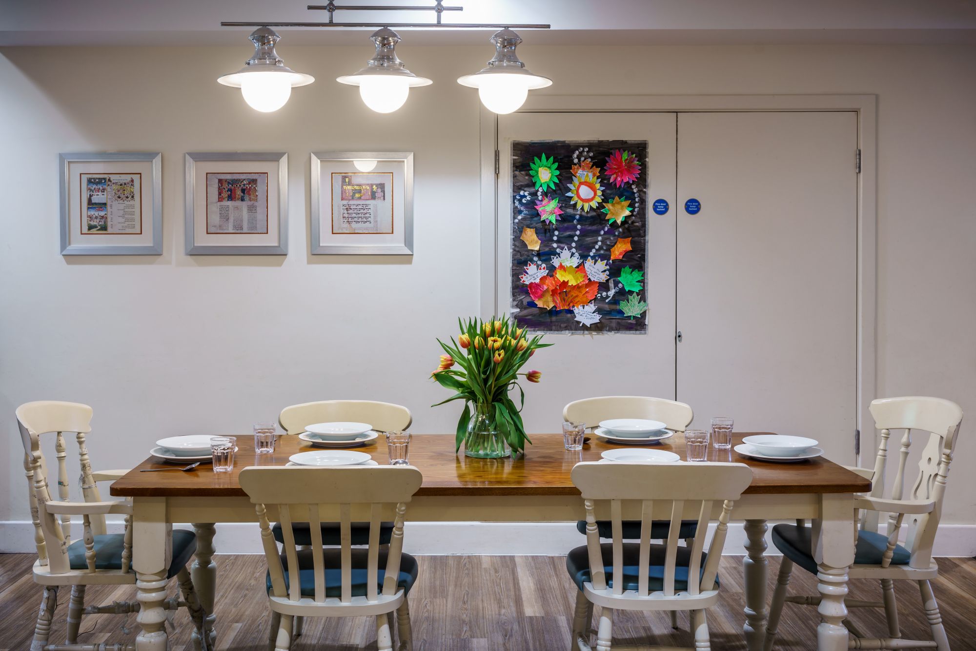 Kun Mor and George Kiss Home Dining Area A large farmhouse-style table with flowers and pictures on the wall behind